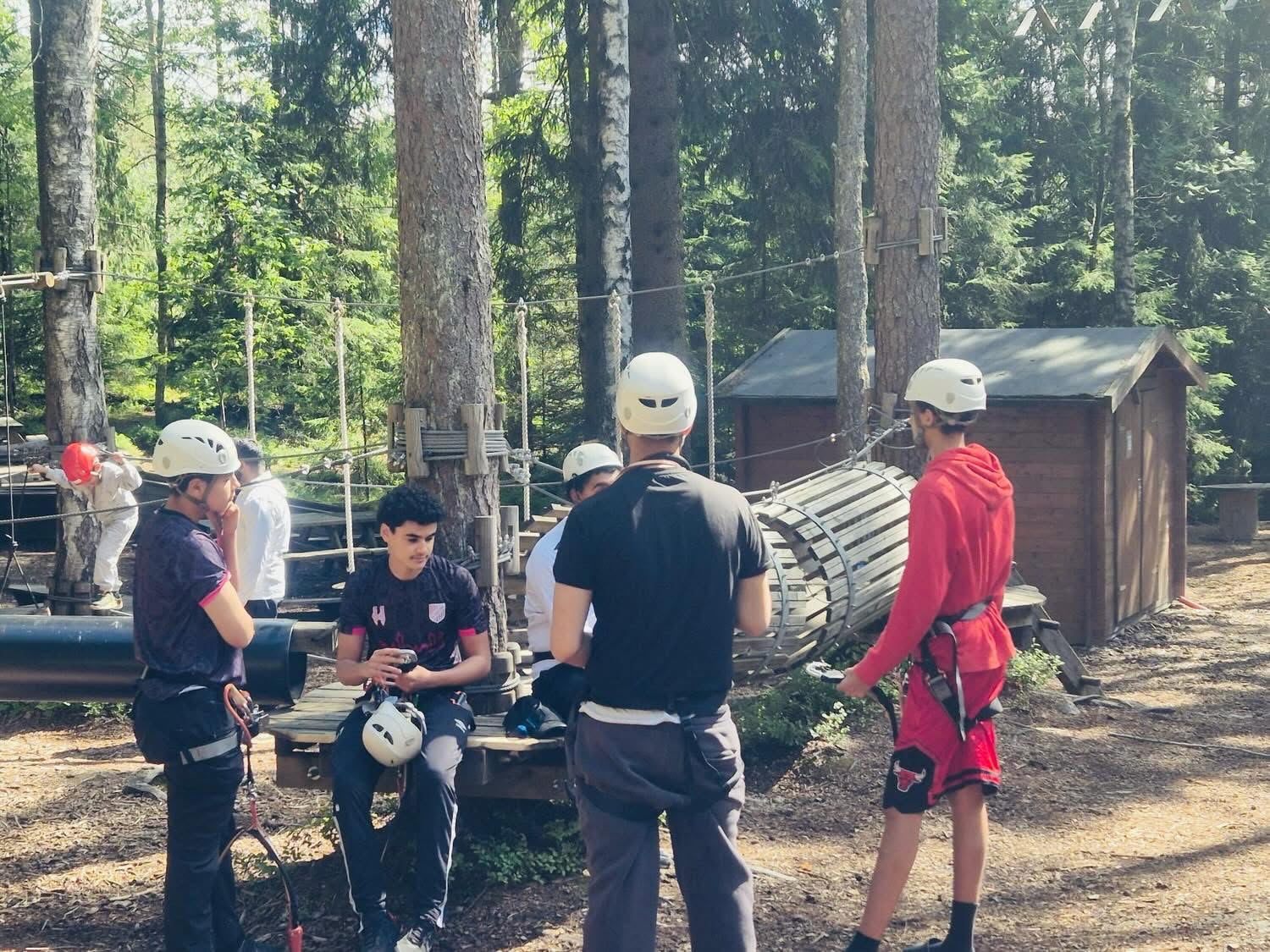 Gjeng med hjelmer tar en pause mellom hindrene